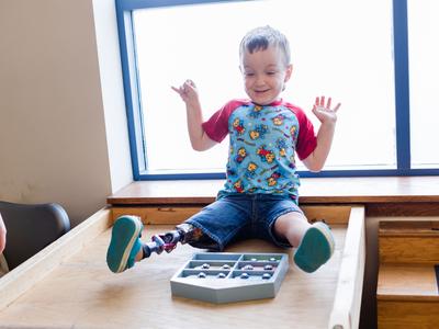 A young boy with arms up in excitement