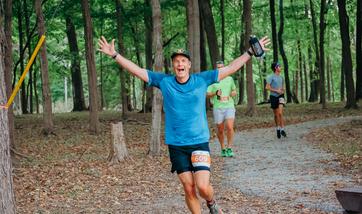 man running with outstretched arms and a big smile